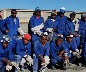 ‘n Deel van die groep werkers van Omega Ondernemings wat baat vind by Perlemoenplaaskontrakte, by die “Grow-out”-tenks wat hulle plaaslik vervaardig word